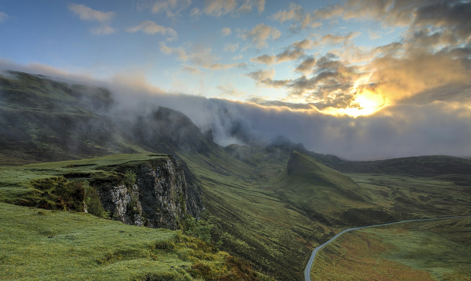 Mist drifting over quiet hills at dawn